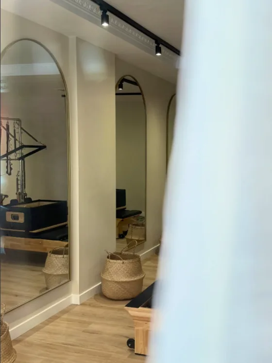 La sala de ACTIUM vista desde la entrada: los espejos en arco y el suelo de madera